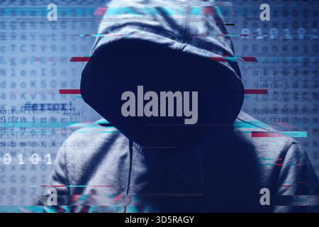 Faceless hooded hacker surrounded by digital computer code and binary digits, concept of cybercrime, data breach, and online security. Selective focus Stock Photo