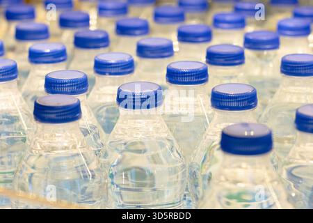 A batch of plastic bottles with blue caps in drinking water Stock Photo
