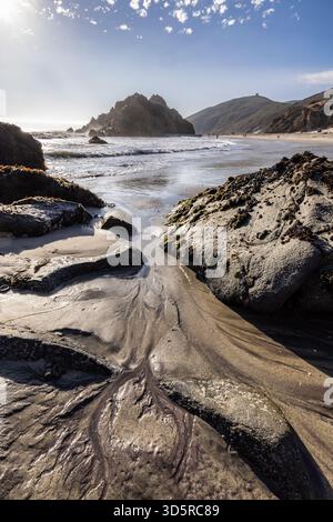 Purple mineral sand patterns flowing between coastal rocks at Pfeiffer Beach, Big Sur, California. Stock Photo