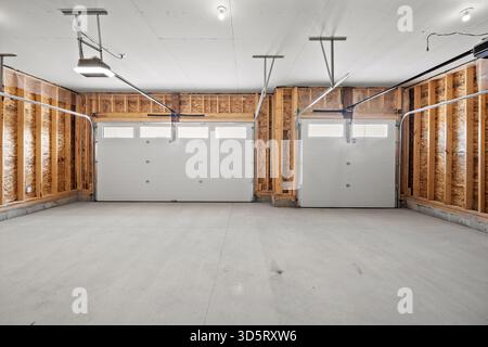Garage with two white doors and a white ceiling. The garage is empty and has a clean, modern look Stock Photo