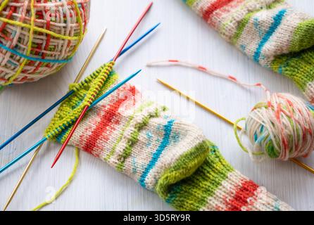Close up of a knitted sock in progress with visible wool yarn and needles, showing detailed texture and stitches, perfect for illustrating traditional Stock Photo