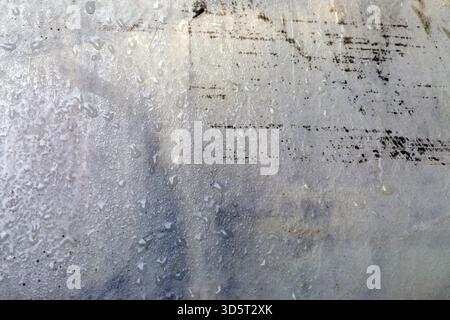 Close-up of a textured, light-colored surface with water droplets and subtle grunge marks. Ideal for backgrounds, design projects, and creative overla Stock Photo