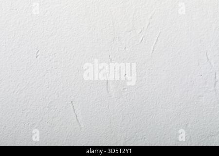 Close-up of a clean white textured wall, featuring subtle patterns and imperfections, ideal for backgrounds or design mockups. Stock Photo