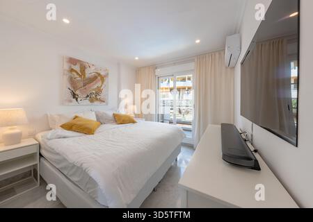 Modern Bedroom with King Size Bed and Balcony Access in holiday apartment Stock Photo