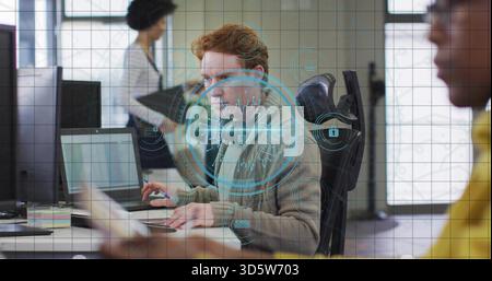 Working redhead in grey sweater typing on laptop in office with hologram security overlay, headset Stock Photo