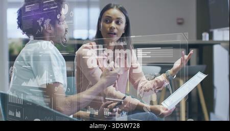 Analyzing AR overlays, two colleagues wearing pink blouse, light shirt with tablet, pen in office Stock Photo