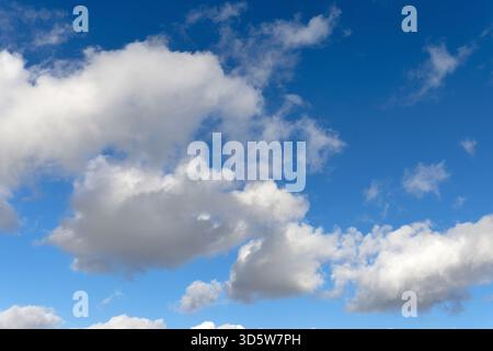 White cumulus clouds drifting across a blue sky Stock Photo