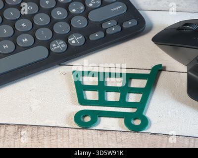Online Shopping: Keyboard, Mouse, Cart - Overhead view of a miniature green shopping cart with a computer keyboard and mouse. Represents the convenien Stock Photo