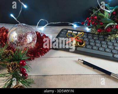 Festive Holiday Workspace with Keyboard - A cozy, decorated workspace for holiday season tasks. Features a keyboard, sparkling lights, a glass ornamen Stock Photo