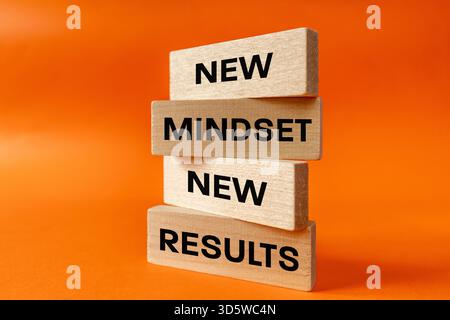 new mindset new results. Concept, personal and business development. Written on wooden blocks. Beautiful orange background. close up Stock Photo