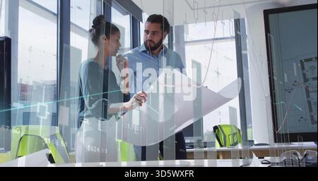 Reviewing blueprint, woman in blouse and man in buttoned shirt at office, with green chairs charts Stock Photo
