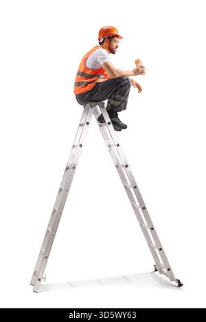 Repairman sitting on a ladder and eating a pastry isolated on white background Stock Photo