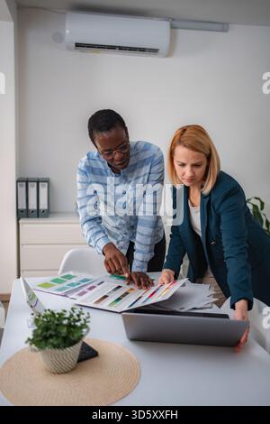 Diverse colleagues collaborating on design project choosing color palette Stock Photo
