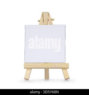Tiny wooden painters easel with emtpy white canvas, standing facing front. Isolated on a white background, Netherlands Stock Photo