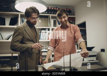 Architect with blueprints and layout design project at office bureau Stock Photo