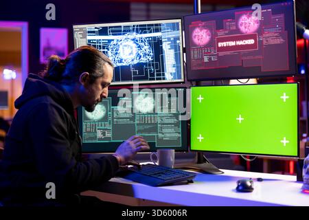Hacker doing covert operations using AI on isolated screen PC to bypass advanced security. Rogue programmer engineering data theft script to penetrate firewalls using chroma key computer Stock Photo
