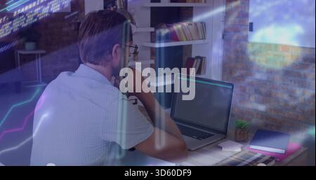 Working middle-aged man wearing eyeglasses light tee typing on laptop at home with data overlays Stock Photo