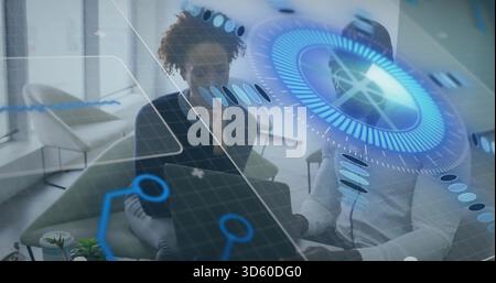 Examining two colleagues in formal wear consulting open laptop in office lounge, blue HUD Stock Photo