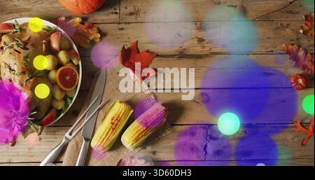 Displaying roasted bird on rustic table, with grilled corn, carving set, bokeh overlays, copy space Stock Photo