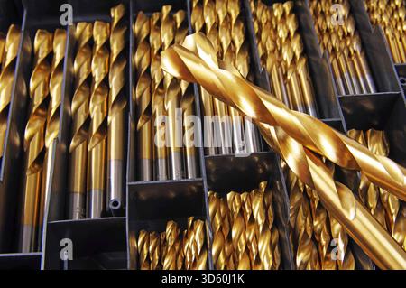 two crossed drill bits and a assortment box of metal drill bits in the  background Stock Photo