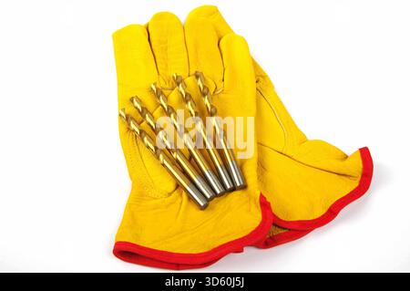 metal drill bits and leather work gloves on a white background Stock Photo