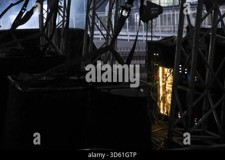 Moody dark night backstage with an urban metal structure. This mysterious scene features reflection of city light on window, creating an abstract and Stock Photo