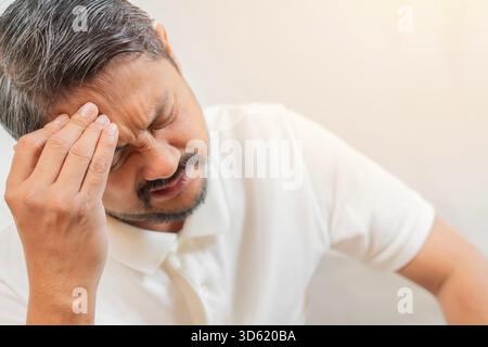 Mind, health problem and stress concept. Close-up unhappy Asian man suffering from headache over white background Stock Photo