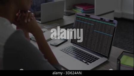Showing silver laptop running terminal in office, man wearing light top, sticky notes, copy space Stock Photo