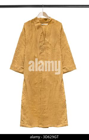 Yellow long oversize kimono bathrobe hanging on clothes rack isolated over white Stock Photo
