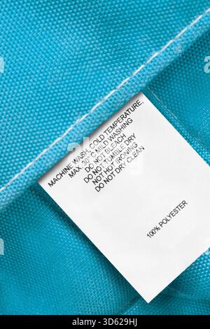 Washing instructions and fabric composition label on light blue fabric background Stock Photo