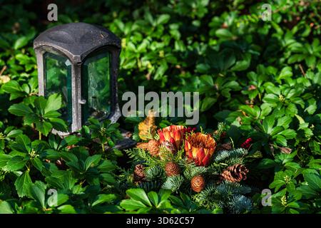 Colorful flowers are arranged among lush green leaves near a decorative lantern. This peaceful setting captures a moment of tranquility in a garden du Stock Photo