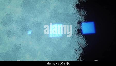Glowing three illuminated squares drifting across frosted glass panel, showing rippled texture Stock Photo