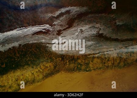 Aerial view of the coast where the sea kisses the land, a symphony of browns, yellows, and greens blend under swirling white patterns, Dornoch, United Stock Photo