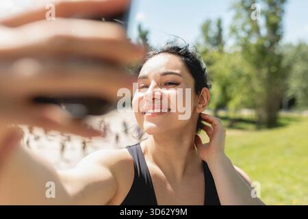A young woman, who uses invisible orthodontic alignators, smiles making a selfie after playing Stock Photo