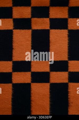 Bright black and orange checkered blanket abstract pattern background, warmth Stock Photo