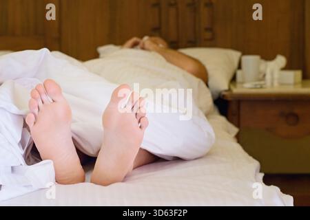 Ill man lying in the bed suffering from  flu and cold Stock Photo