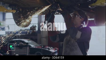 Grinding woman tech wearing PPE using grinder under lifted car on hydraulic lift sparks, copy space Stock Photo