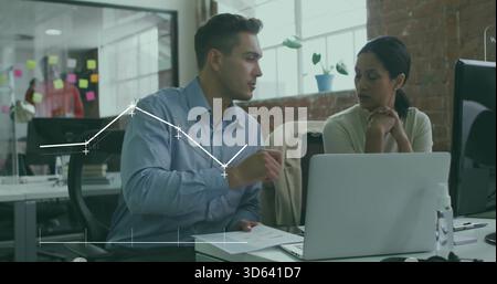 Discussing seated coworkers in light office attire at desk reviewing documents and data with laptop Stock Photo