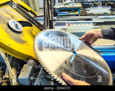 Voronezh, Russia - October 09, 2024: Saw blade of automatic circular saw in hands of worker Stock Photo