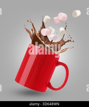 Fresh marshmallows falling into cup with hot cocoa on grey background Stock Photo