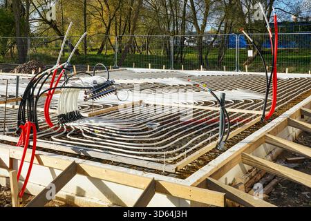 Underfloor heating pipes installed in concrete base at new house construction site, energy-efficient heating system and modern building technology Stock Photo