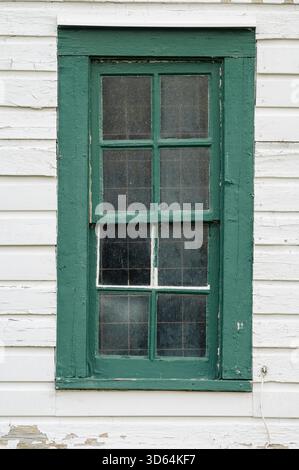 Historic window with green trim on white siding, Alberta, Canada Stock Photo