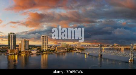 Warm storm-charged clouds sweep over Jacksonville as the city’s towers rise against a sky alive with shifting color and dramatic weather. Stock Photo