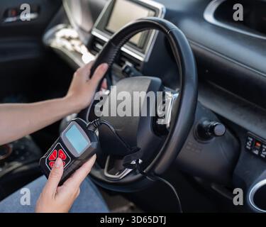 Woman using OBD2 diagnostic scanner.  Stock Photo