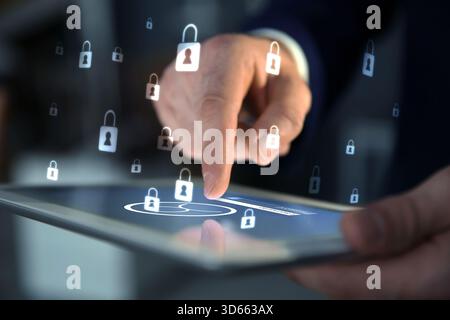 Password and username required to sign in. Man using tablet computer, closeup. Locks flying from device. Cyber security and data protection concept Stock Photo