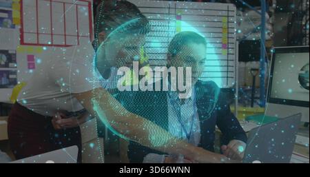 Collaborating office team wearing business-casual reviewing project on laptop, AR globe overlay Stock Photo