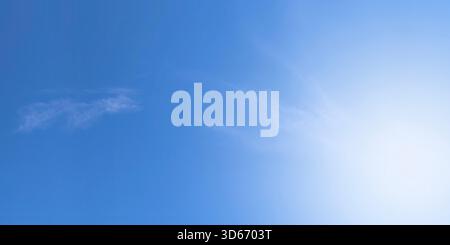 Clean soft pale blue sky with very faint almost imperceptible wisps cirrus clouds. Sky smooth gradient shifting from slightly lighter shade bottom pas Stock Photo