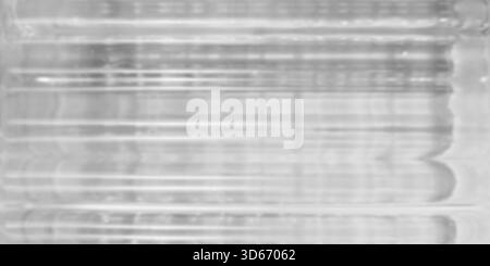 monochromatic low-contrast abstract background featuring soft heavily blurred view through textured glass. Dominated by pale gray and white tones wher Stock Photo