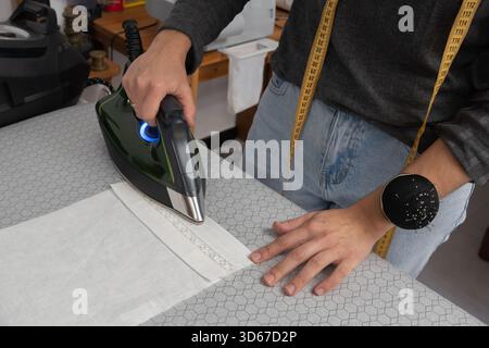 Seamstress concentrating while working on a sewing machine in her workshop Stock Photo