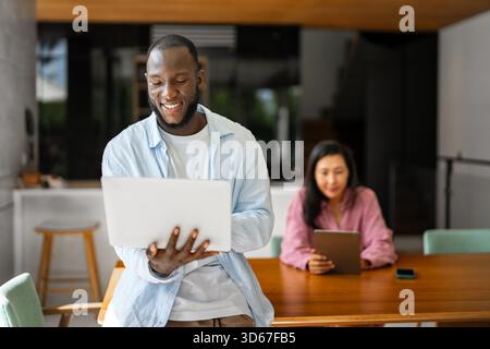 Multicultural couple working remotely, planning finances and investments online. Digital lifestyle Stock Photo
